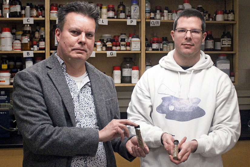 Dr. Lee Wilson and Bernd Steiger are holding small vials of brown coloured pellets