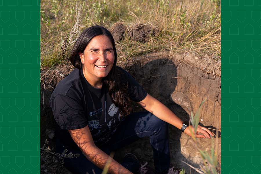 Melissa Arcand sitting in a large hole in a field