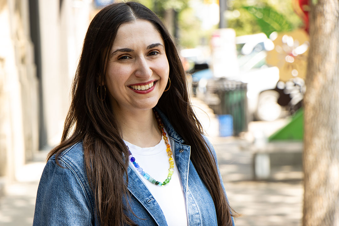 Headshot of Leah Horlick in jean jacket and white t-shirt standing outside