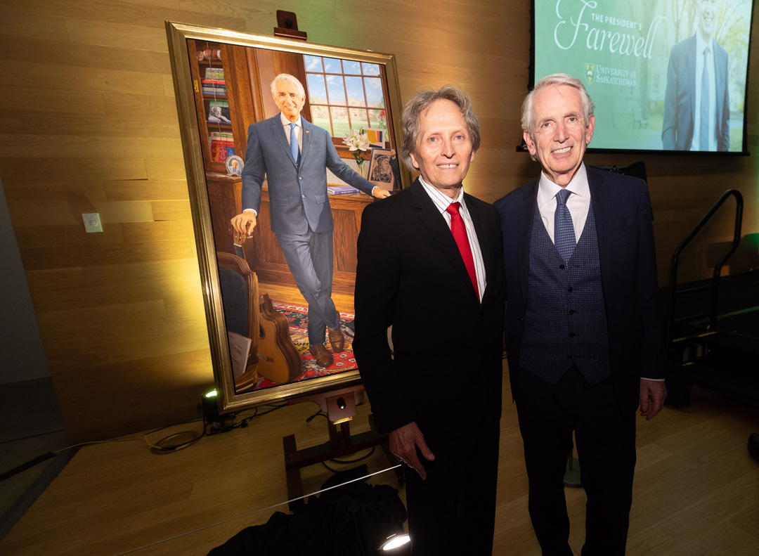 Renowned Canadian artist Phil Richards and USask President Peter Stoicheff are pictured beside the president’s official painted portrait. (Photo: David Stobbe)